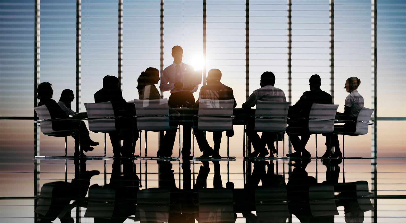 Executives in a boardroom overlooking the Gulf at sunset